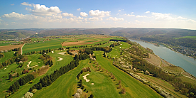 Luftaufnahme eines Golfplatzes Weitläufiger Golfplatz mit grünen Fairways und Fluss im Hintergrund.